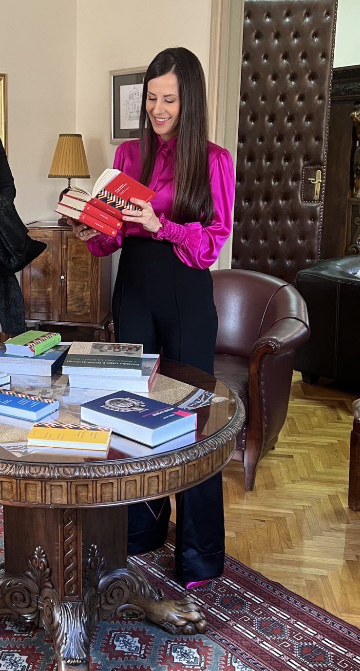 Тамара Вучић разгледа три књиге народних пословица у издању Архива